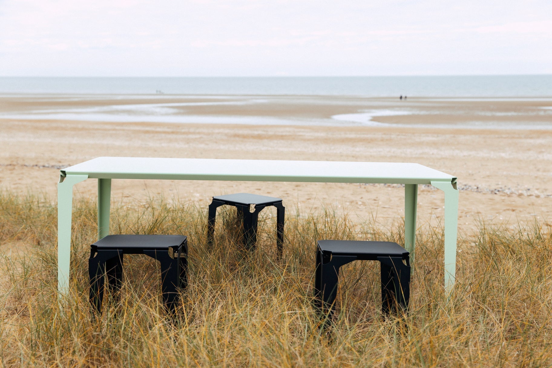 Table Nantes et tabouret Pontivy sur une dune face à la mer