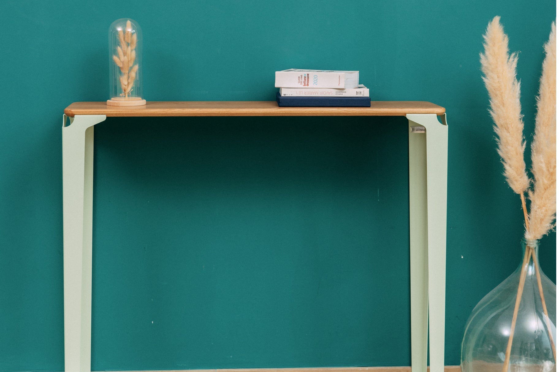 console vittel vert pastel le long d'un mur vert canard