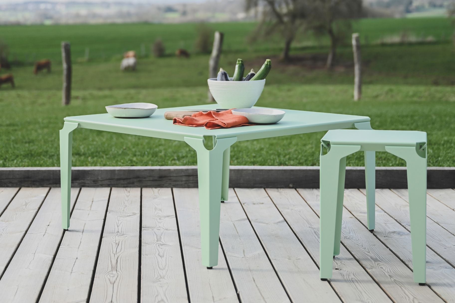 table et tabouret en acier thermolaqué vert pastel sur une terasse