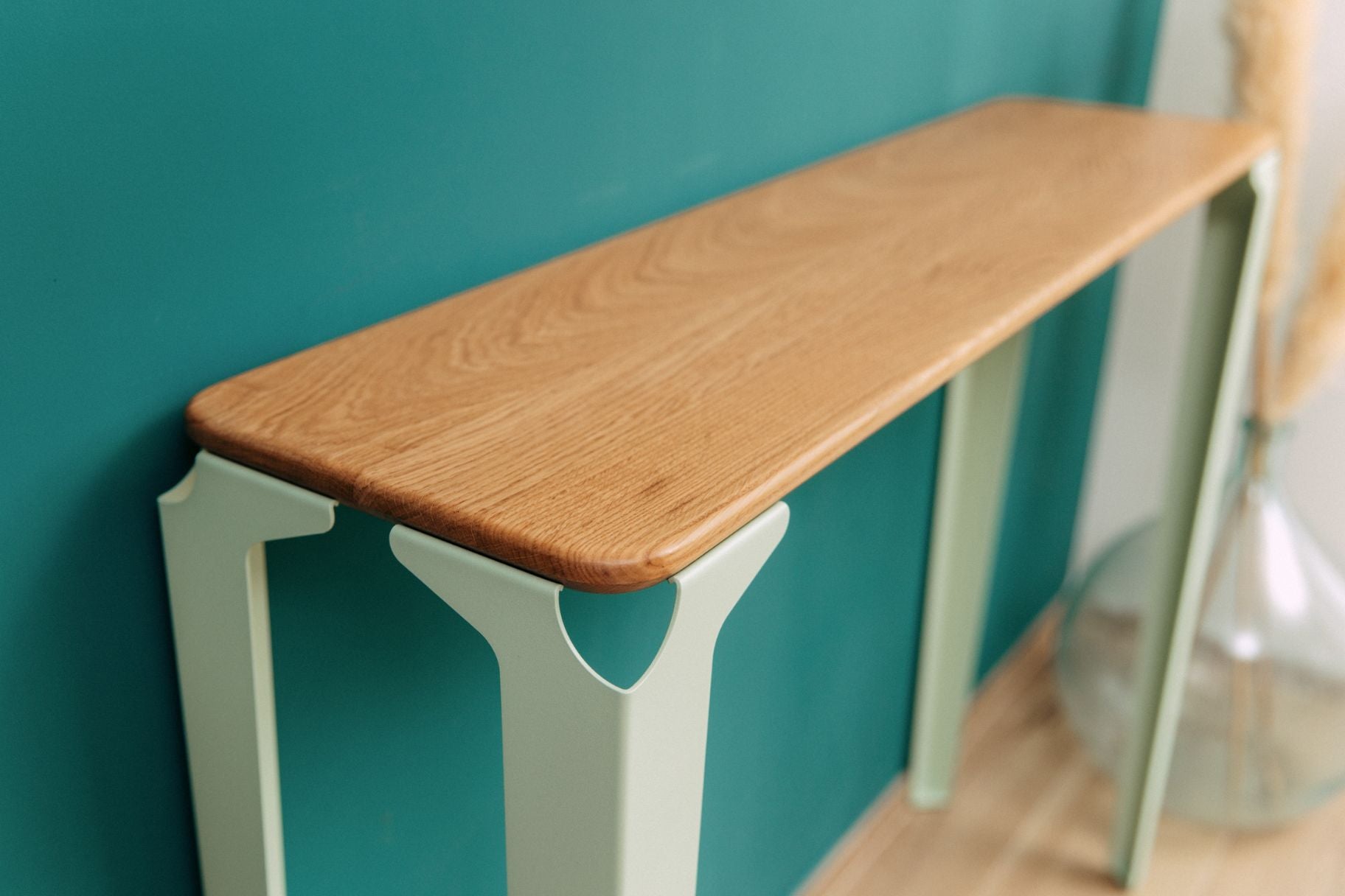Console vittel vert pastel et plateau en chêne massif le long d'un mur vert