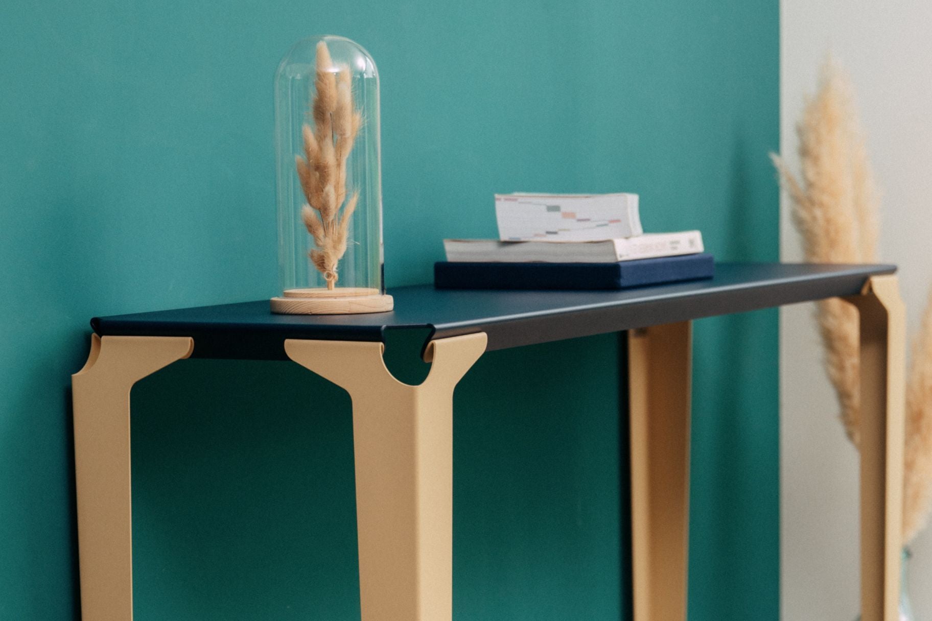 Console chantilly beige et bleu acier sur un mur vert et de la décoration