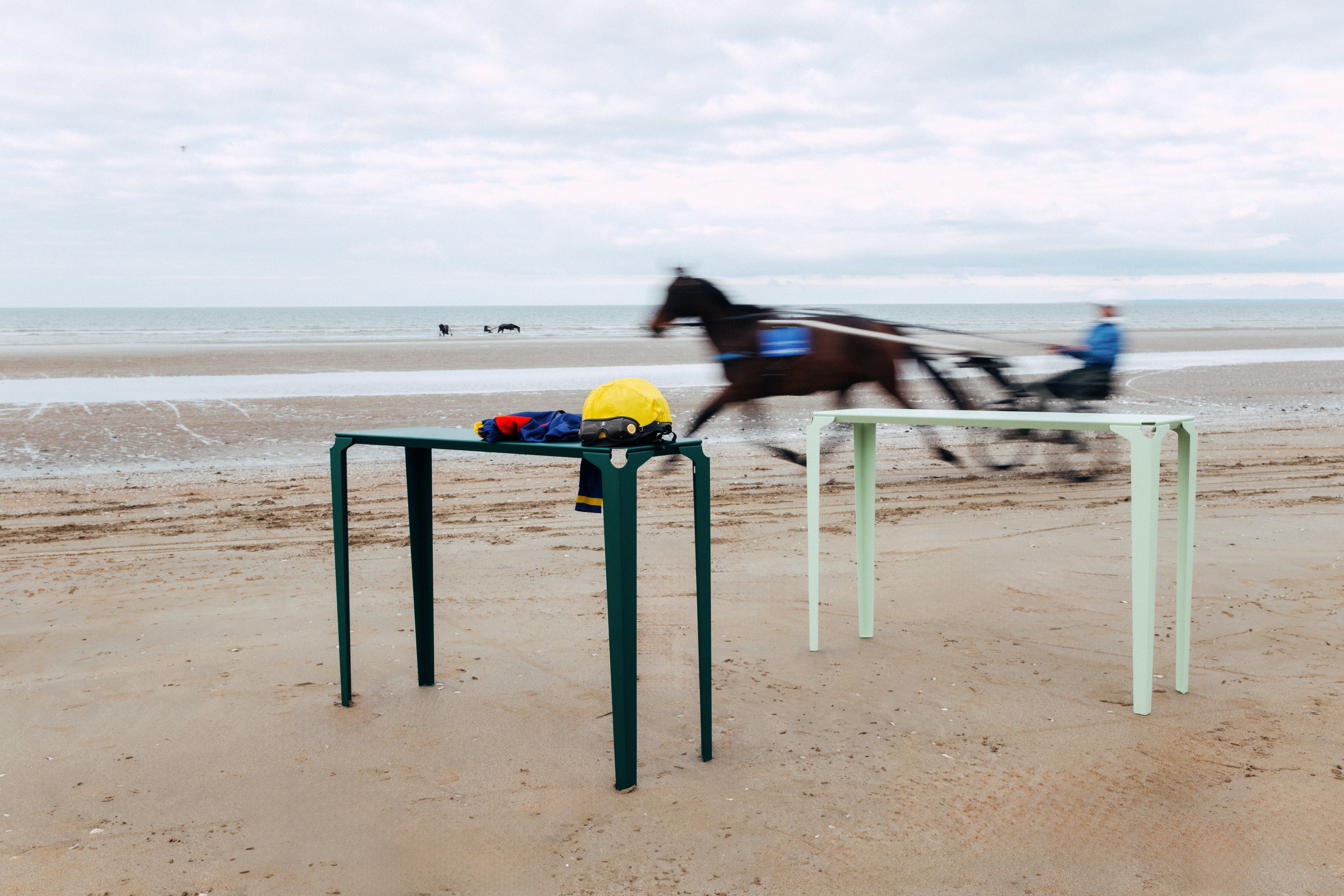 consoles en acier de couleur beige et rose  sur la plage avec un sulky et son driver