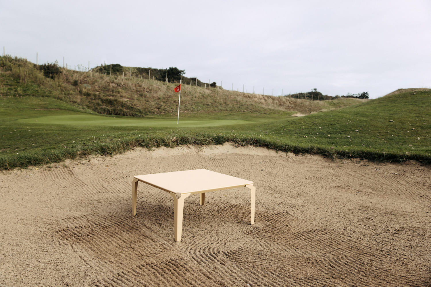 Au milieu d'un bunker, table basse en acier de couleur beige 