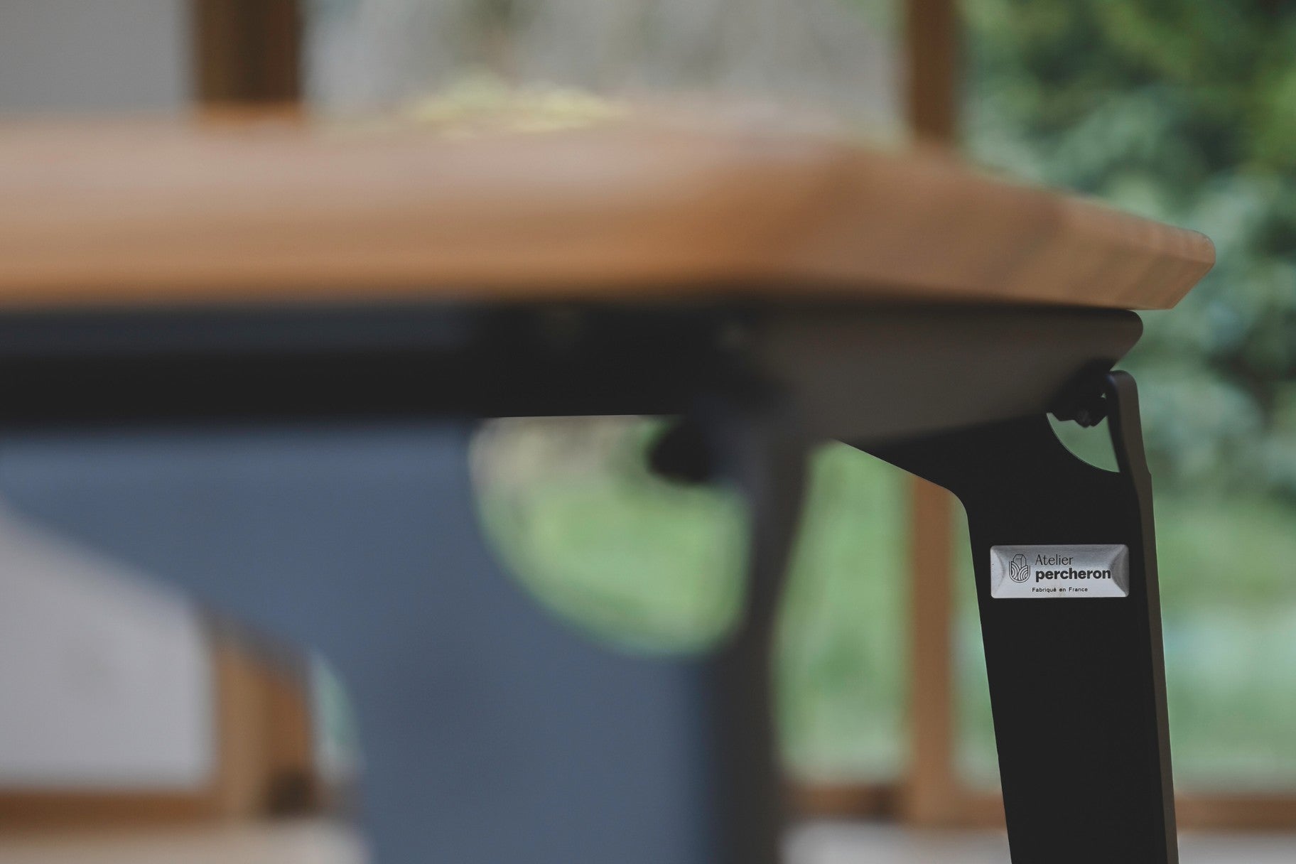 Vue du logo discrtement posé sur le pied de table en acier thermolaqué